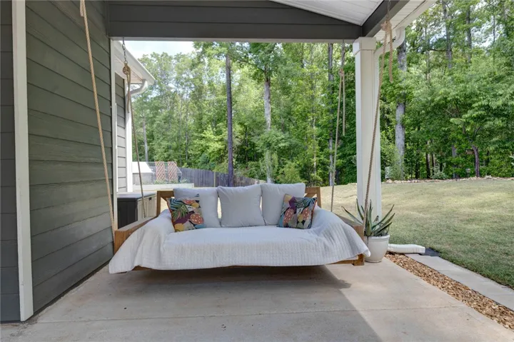 This serene patio offers a tranquil retreat with a porch swing, perfect for outdoor relaxation.