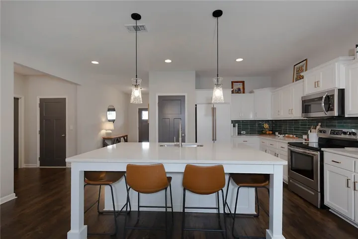 This luminous kitchen features an expansive island, gleaming countertops, and modern appliances perfect for culinary adventures.
