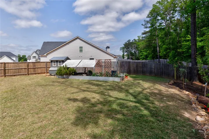 This expansive yard offers ample space for outdoor enjoyment and features a charming garden.