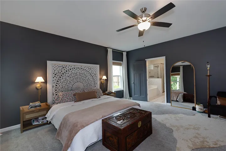 This spacious primary bedroom offers comfort and direct access to a luxurious private bathroom.