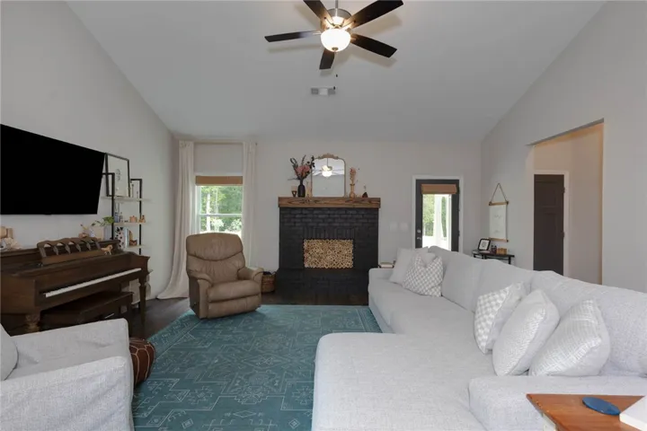 This inviting living area features ample space, a fireplace, and hardwood flooring.