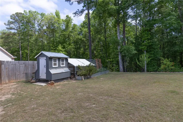 This expansive yard offers ample space, a quaint shed, and mature trees for privacy.
