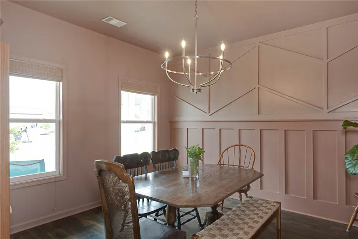 This inviting dining area features elegant paneling and ample natural light, perfect for gatherings.