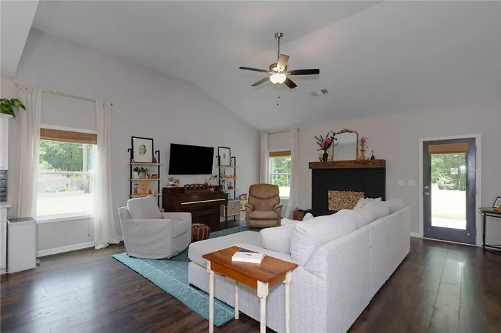This inviting living area boasts rich wood flooring and a cozy fireplace, perfect for gatherings.