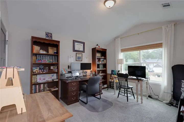 This versatile room offers a comfortable and efficient home office setup, complete with ample shelving.
