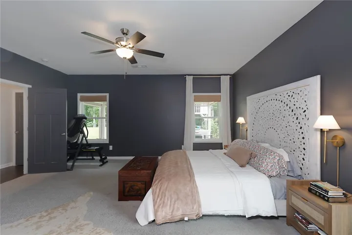 This spacious bedroom offers a tranquil retreat with comfortable carpeting and ample natural light.