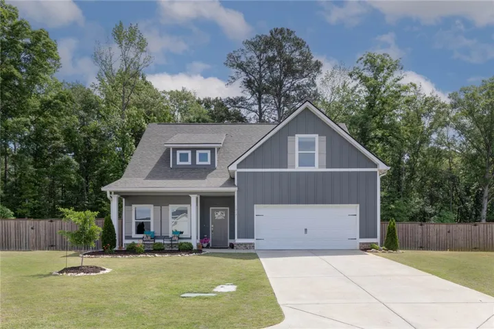This charming residence features a classic design with an attached garage and a welcoming front porch.