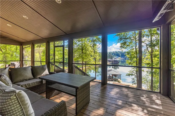 Enjoy tranquil lake views from this expansive screened porch, perfect for relaxing.