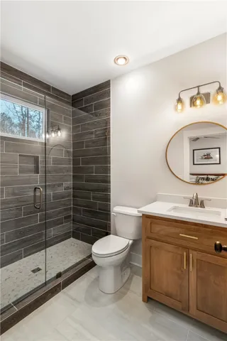 This modern bathroom features sleek tile, a spacious glass-enclosed shower, and a stylish​​‌​​​​‌​​‌‌​‌‌​​​‌‌​‌​‌​‌​​​‌​​ vanity.