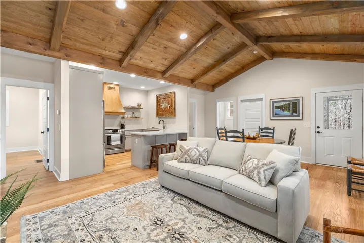 This interior features a high vaulted wood ceiling, open-concept living, and warm hardwood floors.
