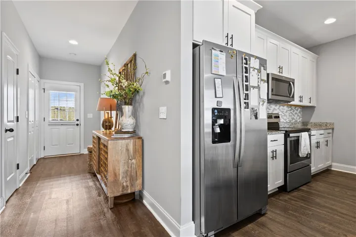 This inviting home boasts a bright kitchen and a welcoming entrance with warm wood flooring.