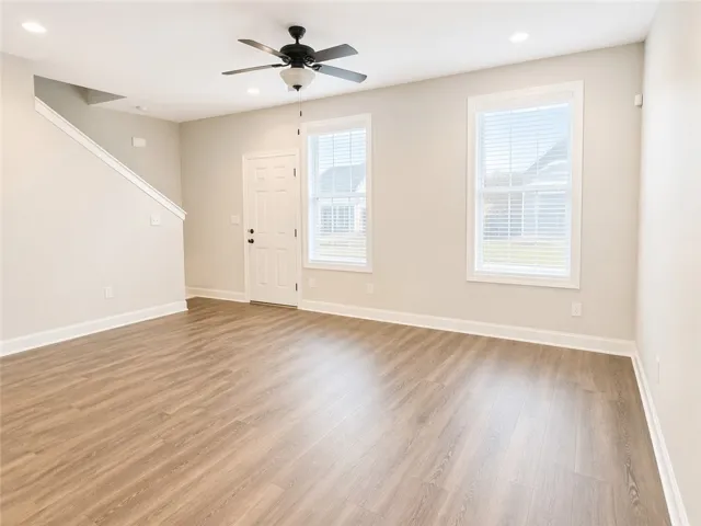 This inviting living space features warm flooring, abundant natural light, and elegant ceiling details.