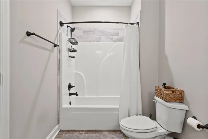 This clean and functional bathroom features a shower-tub combination and modern fixtures for daily comfort.