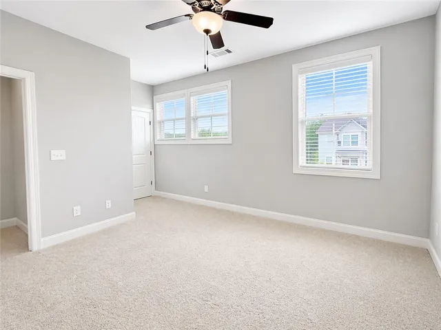 This airy bedroom offers a comfortable retreat with ample natural light.