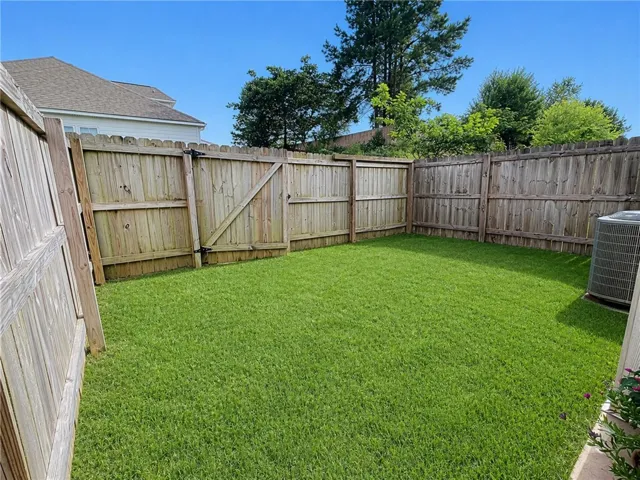 This spacious, fenced backyard offers a private green oasis for outdoor enjoyment.