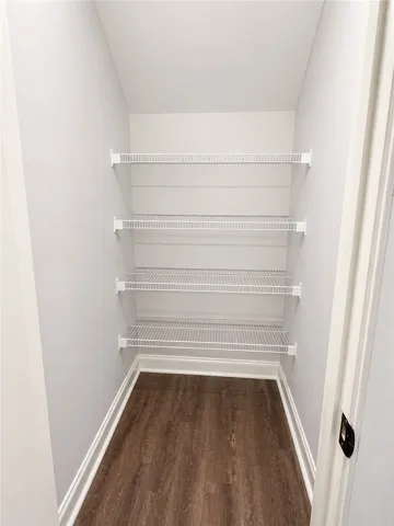This spacious kitchen pantry closet offers wire shelving & rich flooring.