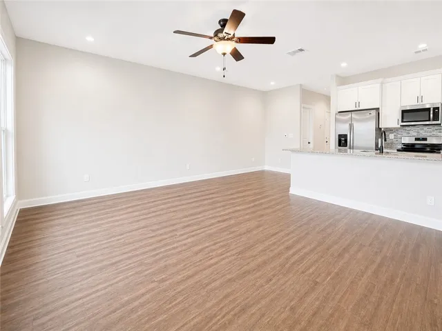 This bright, open concept living area seamlessly connects to a contemporary kitchen, perfect for modern living.