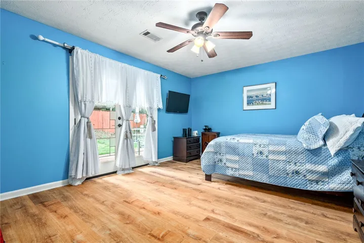 This cozy bedroom features durable wood flooring and direct outdoor access.