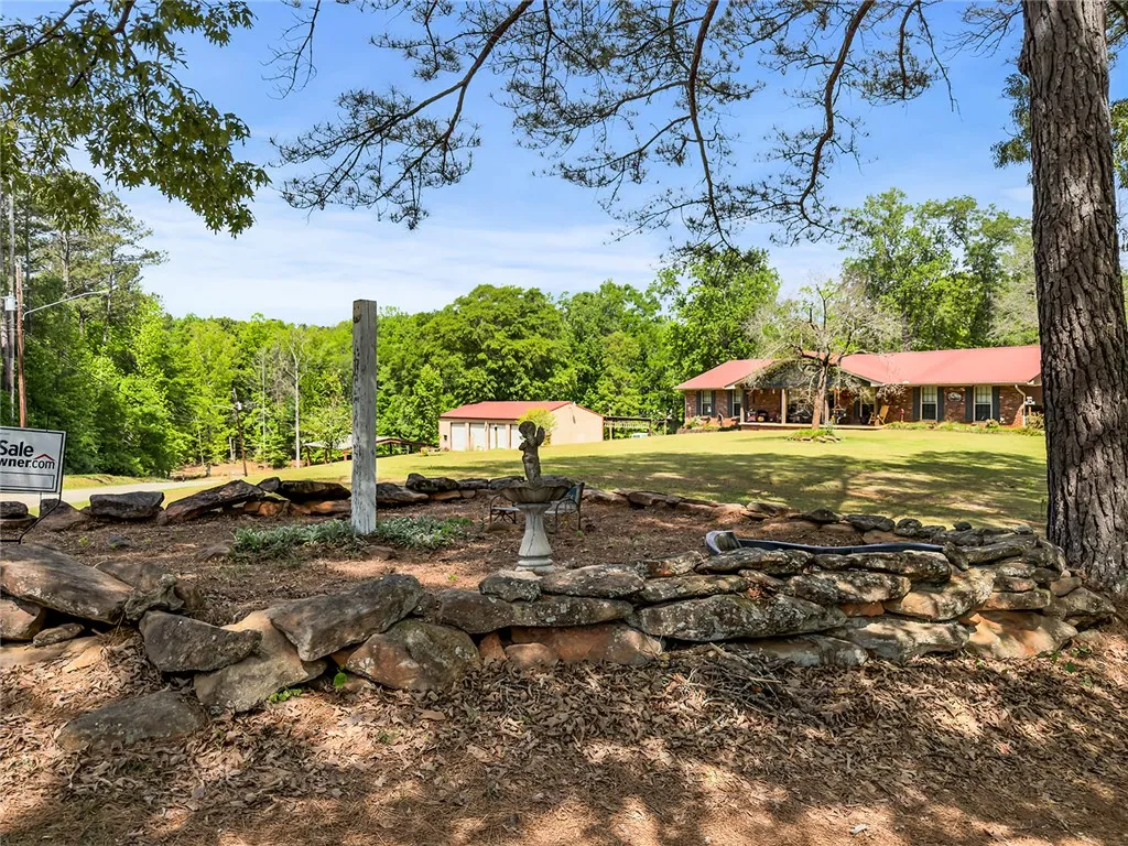 This expansive property offers a private yard and a charming front view of the main house and detached garage.