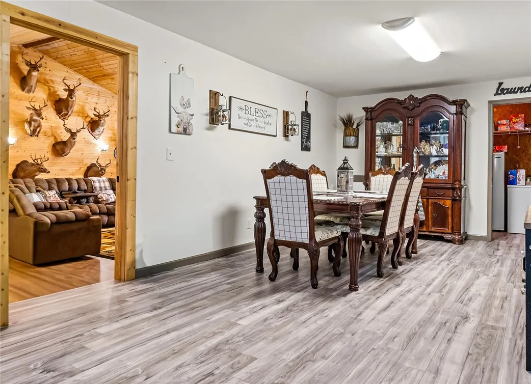 This spacious dining room features elegant flooring and an inviting ambiance perfect for gatherings.