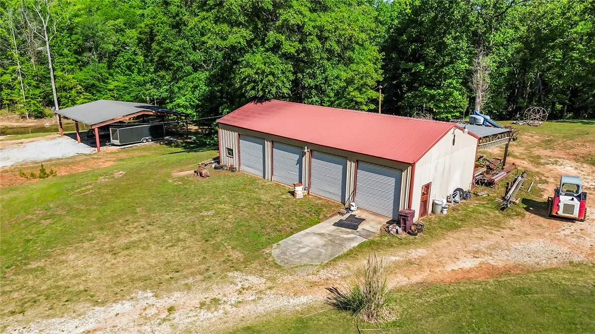 This spacious property features a large multi-bay garage and a separate covered structure, perfect for storage or workshops.
