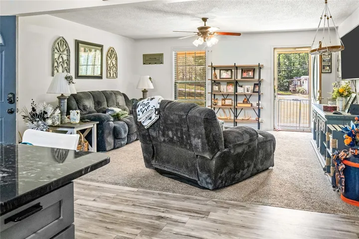 This inviting living space features warm flooring, a ceiling fan, and ample natural light.