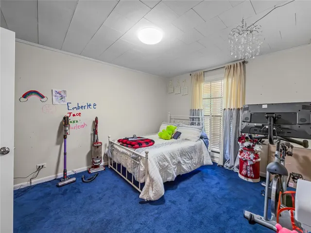 This cozy bedroom features a bright ambiance with ample natural light and plush carpeting.