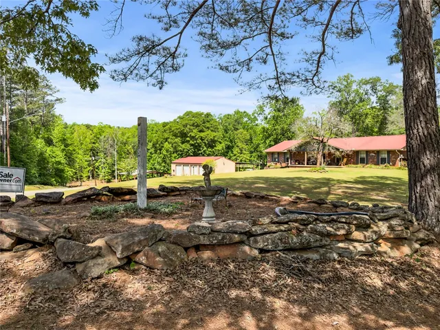 This expansive property offers a private yard and a charming front view of the main house and detached garage.