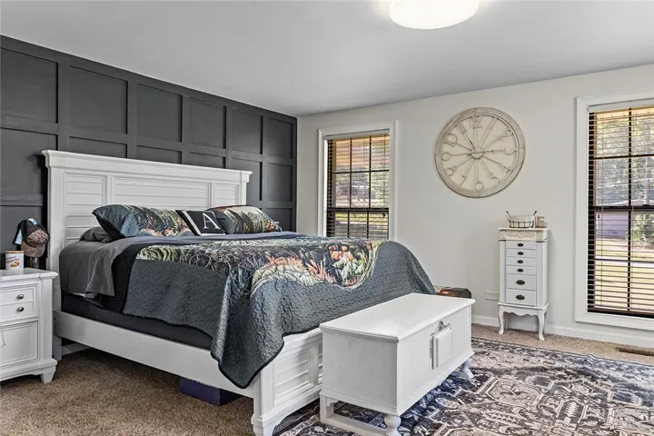 This cozy bedroom features ample natural light and a classic aesthetic.