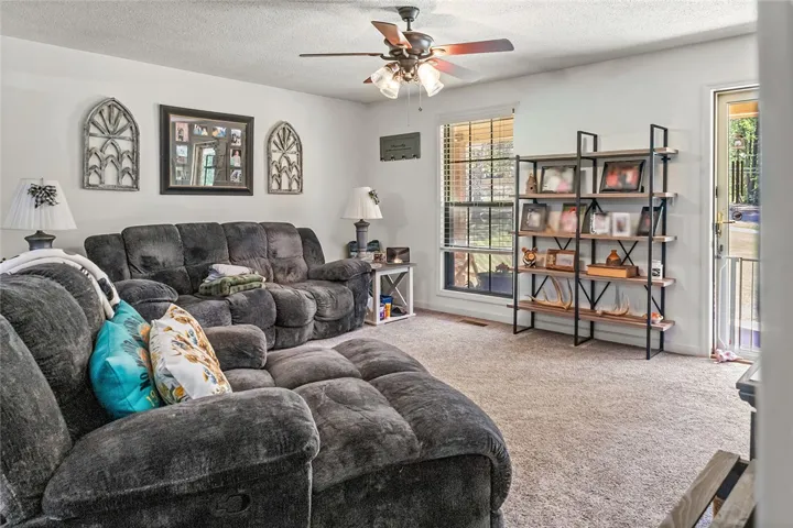This inviting living area features soft carpet and ample natural light, perfect for relaxation.
