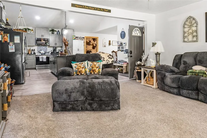This open concept living space features a kitchen with modern appliances and a comfortable living room.