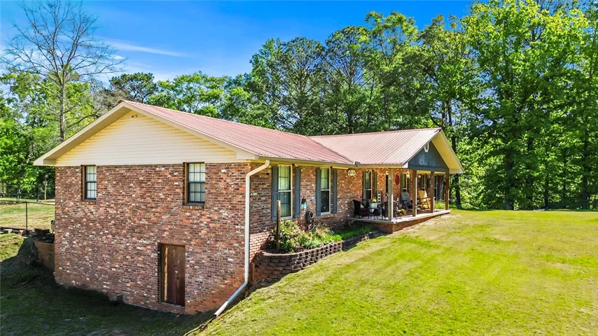 This charming brick home offers a large front porch and a spacious yard surrounded by mature trees.