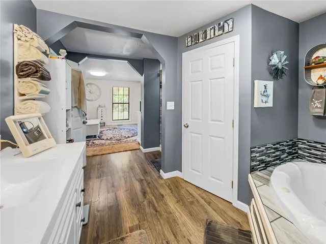 This primary bathroom features warm flooring and a relaxing soaking tub for ultimate comfort.