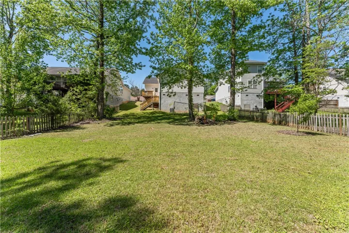 Expansive backyard provides a serene escape with mature trees and privacy fencing.