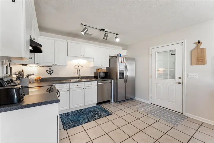 This bright kitchen features modern appliances and ample cabinet space, perfect for culinary endeavors.