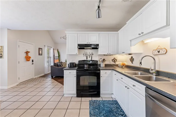 This bright kitchen features white cabinetry, ample counter space, and modern appliances.
