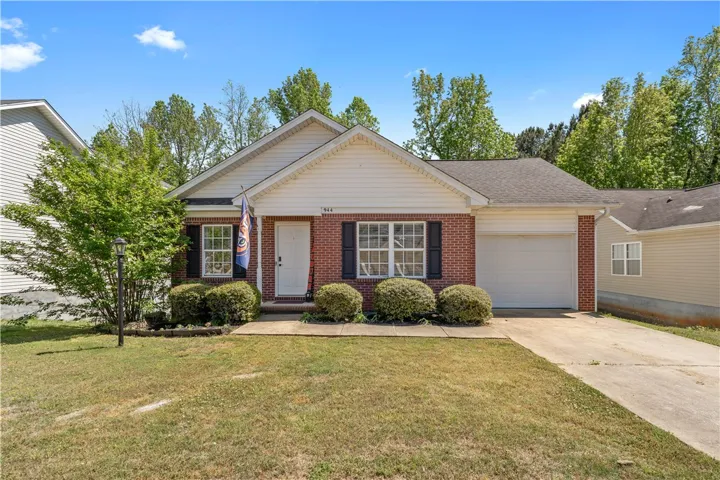 This charming residence features a classic brick exterior and a well-maintained front yard with mature landscaping.