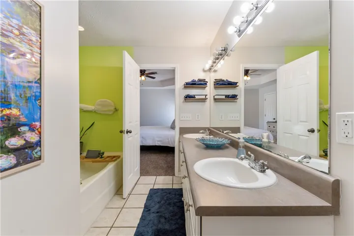 This bathroom features dual sinks and tile flooring.
