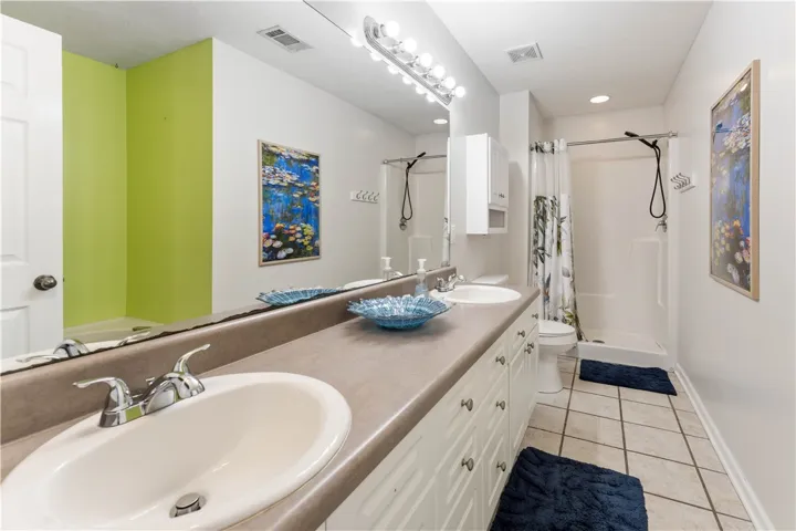 This bright bathroom features a spacious vanity with dual sinks, offering ample personal space.