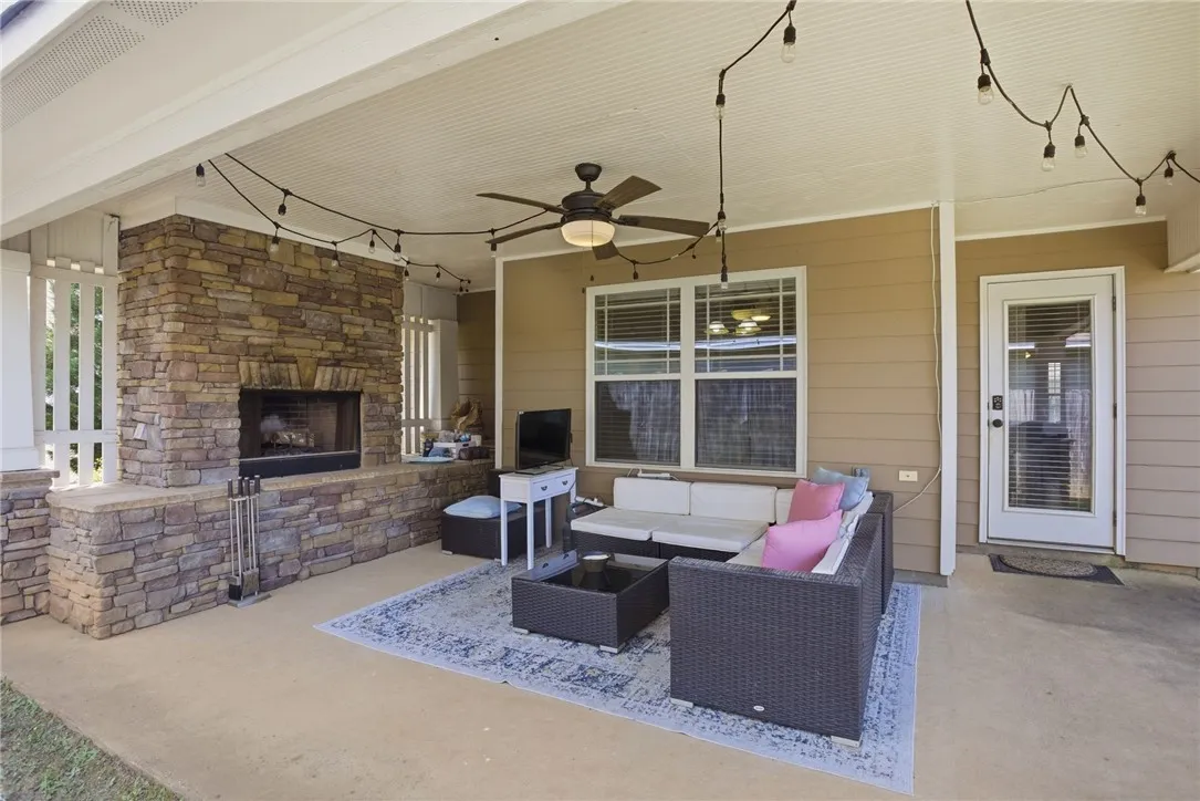 An inviting outdoor living space features a cozy fireplace and ample seating for relaxation.