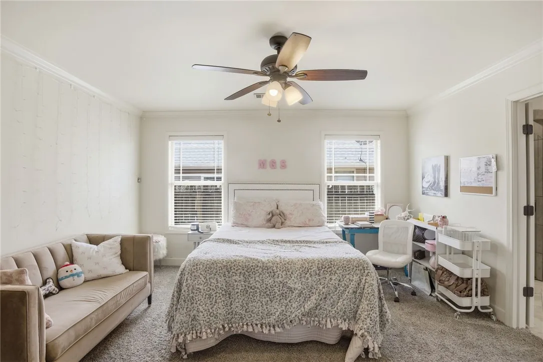 This spacious room features ample natural light and plush carpeting, creating a comfortable living space.