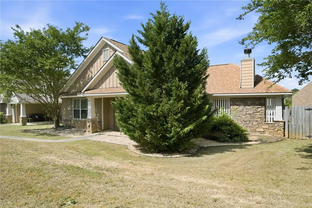 This charming home features a lovely facade with mixed materials, creating a welcoming curb appeal.