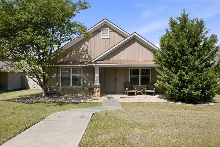 This charming home offers a welcoming facade with a classic design and lush landscaping.