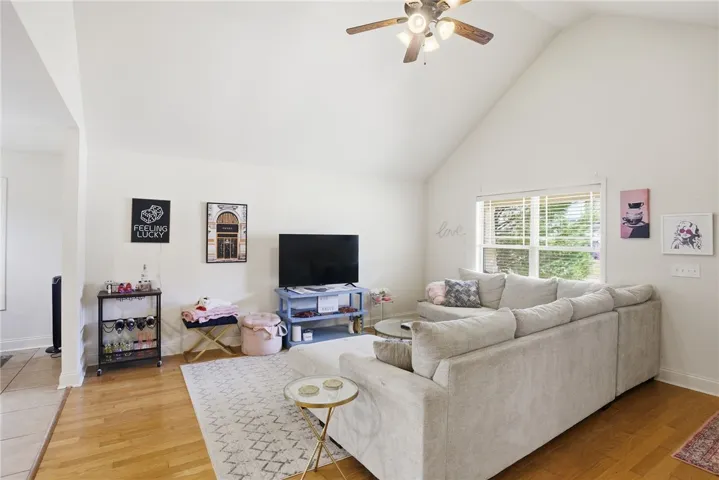 This airy living room features high ceilings and a view of the outdoors.