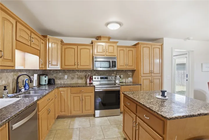 This spacious kitchen offers ample cabinetry, modern appliances, and a convenient island for culinary endeavors.