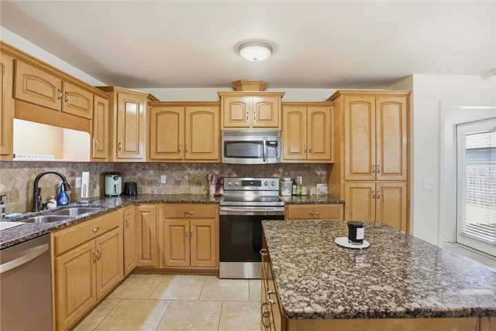 This spacious kitchen offers ample cabinetry, modern appliances, and a convenient island for culinary endeavors.