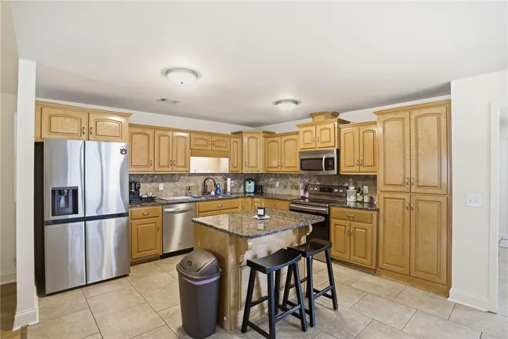 This spacious kitchen offers ample cabinetry, modern appliances, and a convenient central island.