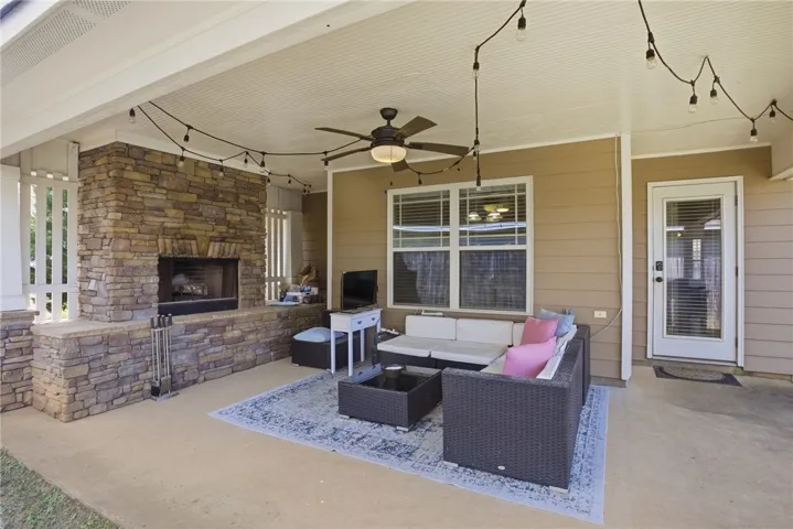 An inviting outdoor living space features a cozy fireplace and ample seating for relaxation.