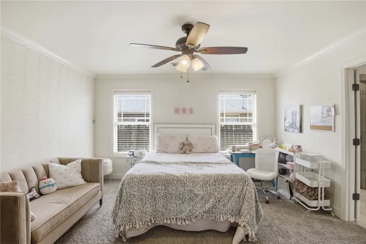This spacious room features ample natural light and plush carpeting, creating a comfortable living space.