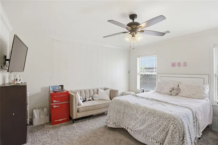 This cozy room offers comfort and ample natural light through its generous windows.